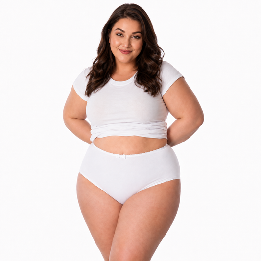A woman modeling a white two-piece lingerie set consisting of a short-sleeve crop top and high-waisted briefs, photographed against a solid white studio background. Front view of women’s plus size high-waisted full coverage brief