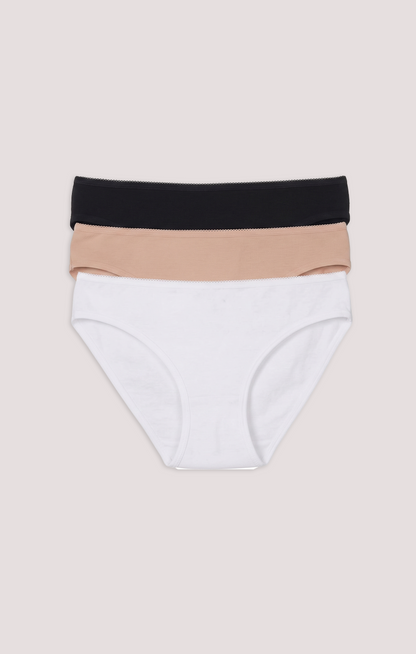 Set of three pairs of underwear in black, beige, and white on a beige background