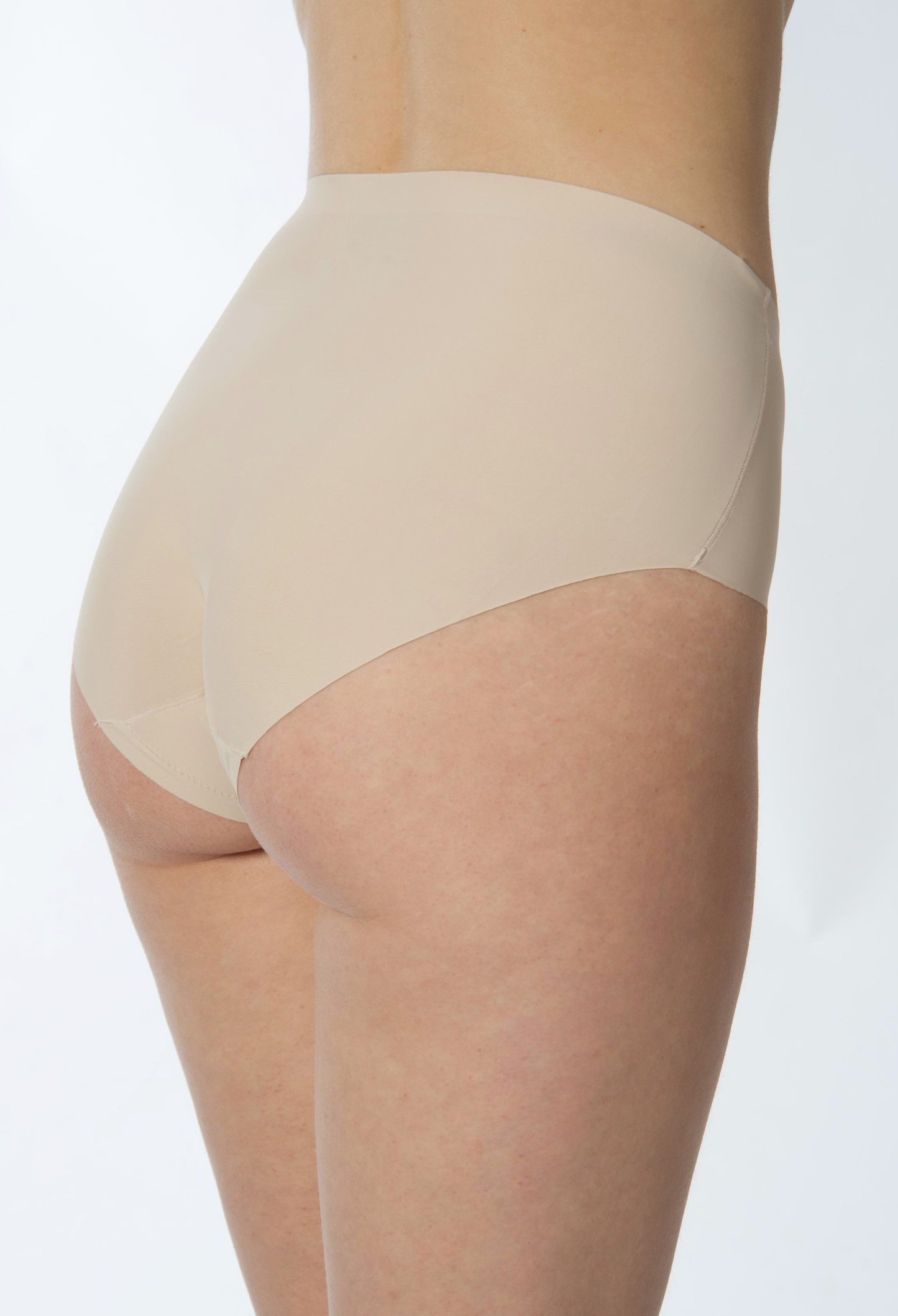 Beige underwear worn by a person on a white background