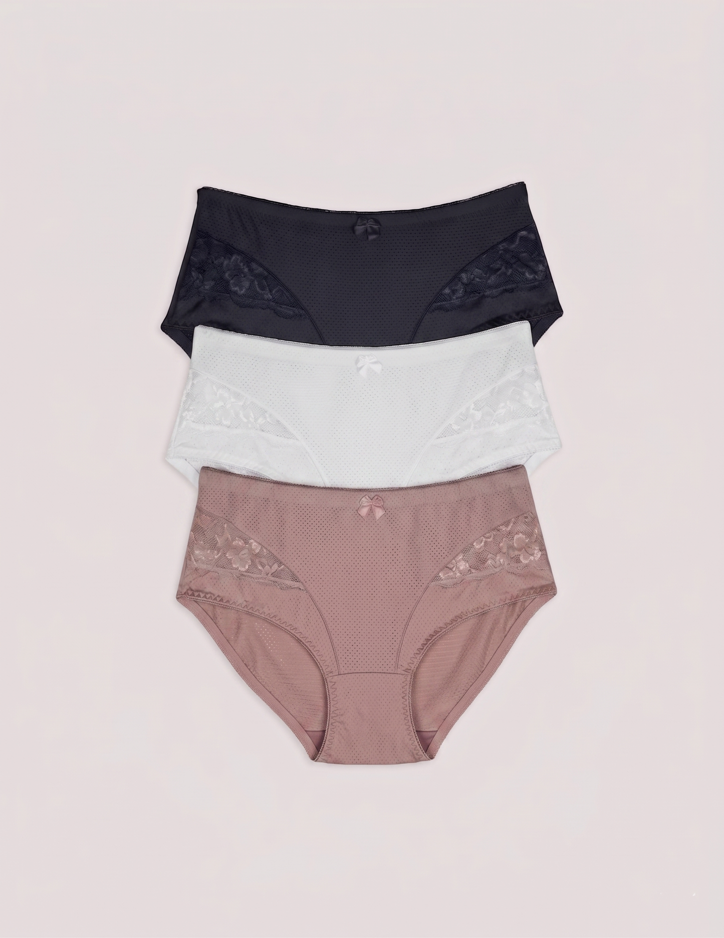 Three pairs of women's underwear in black, white, and pink on a light pink background briefs cullottes