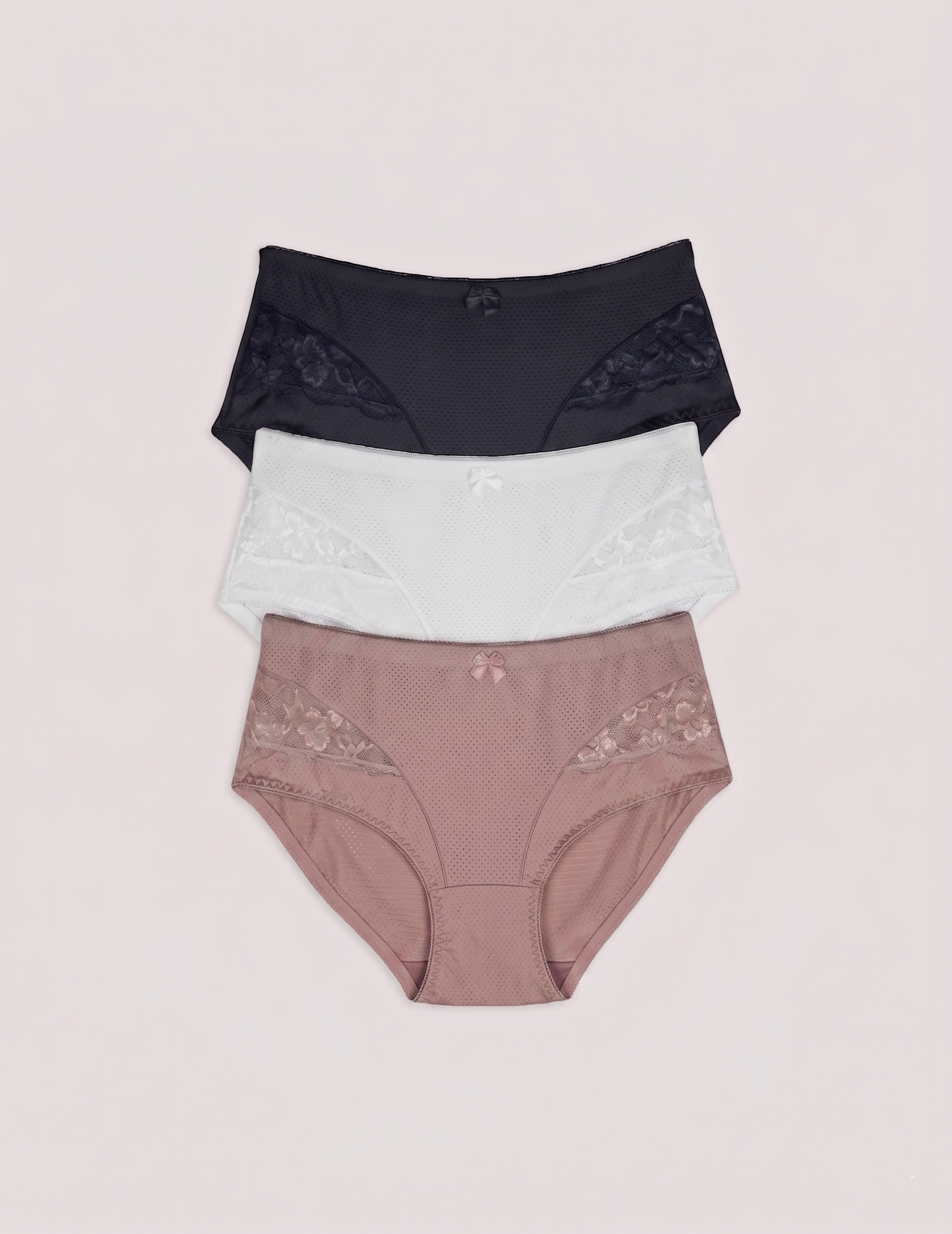 Three pairs of women's underwear in black, white, and pink on a light pink background briefs cullottes