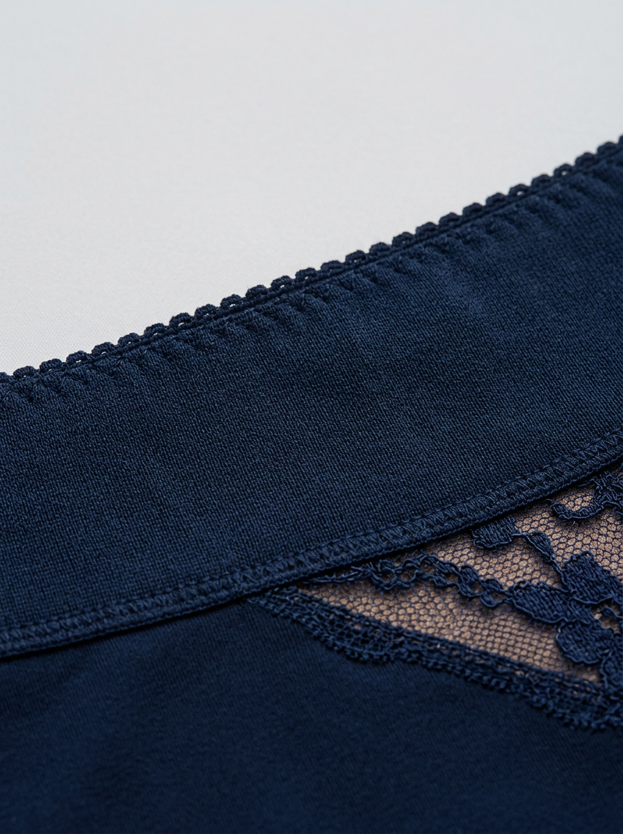 Navy blue lace-trimmed underwear on a light gray background