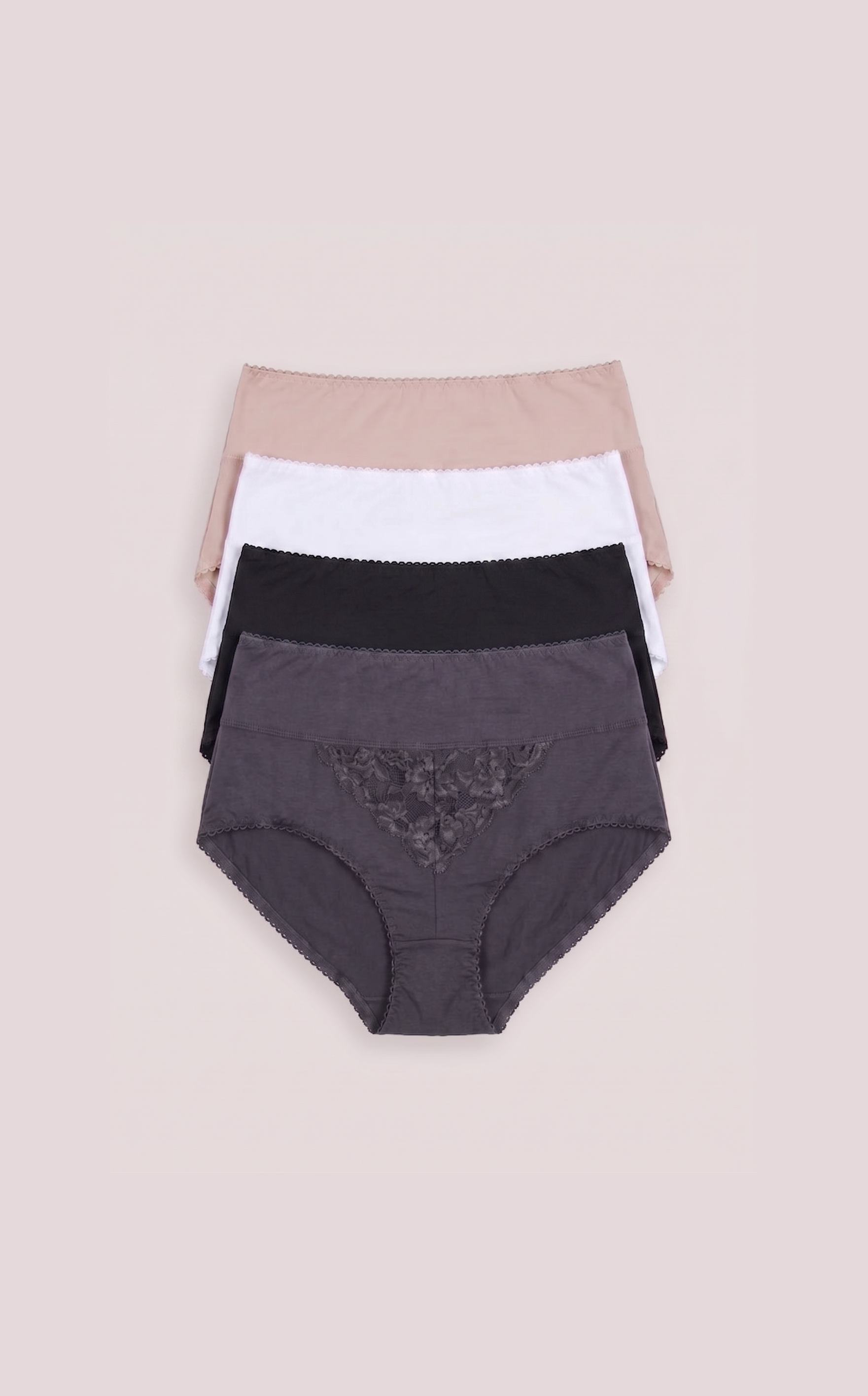 Three pairs of women's underwear in black, white, and beige on a beige background