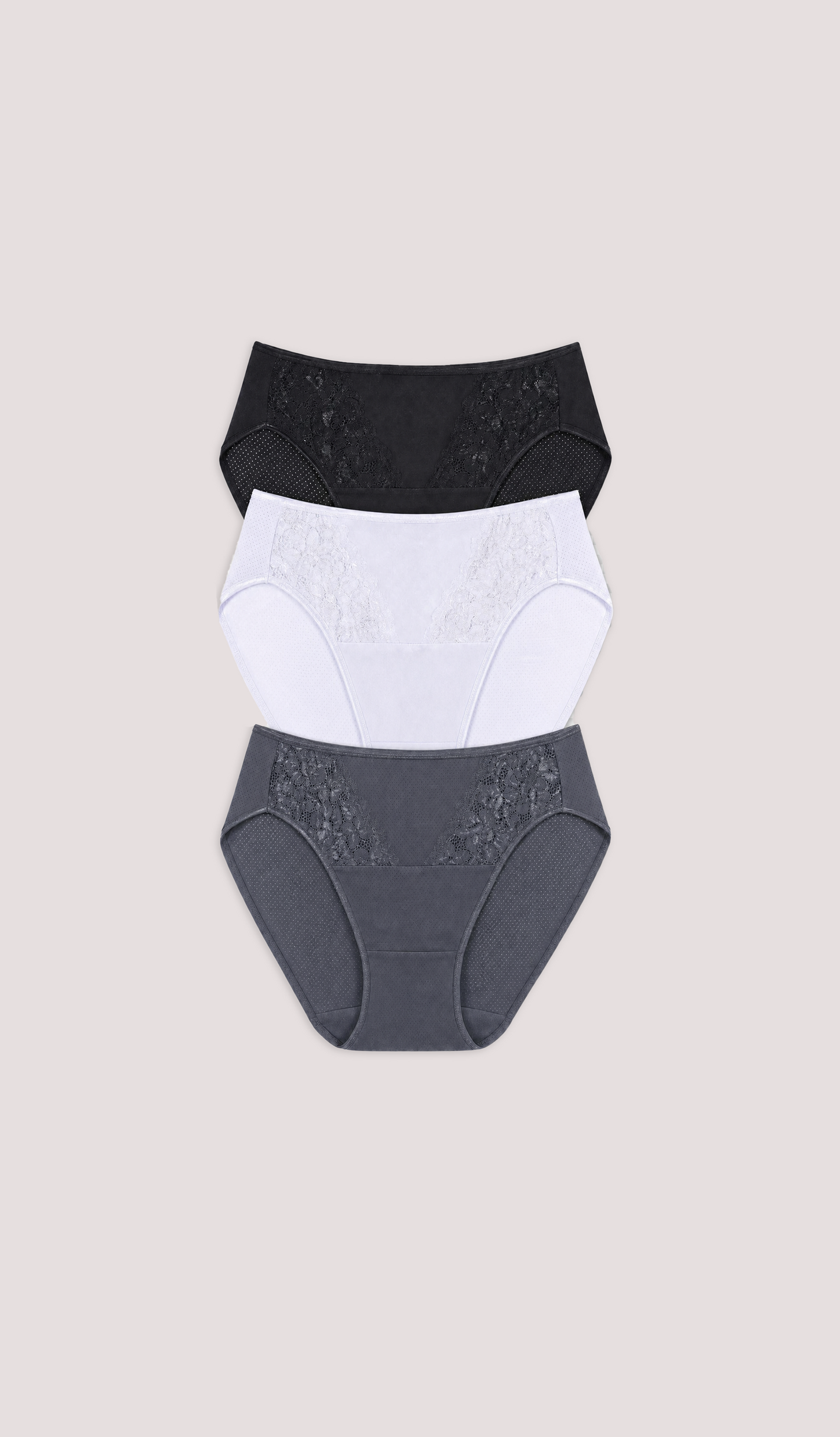Three pairs of women's underwear in black, white, and gray on a beige background