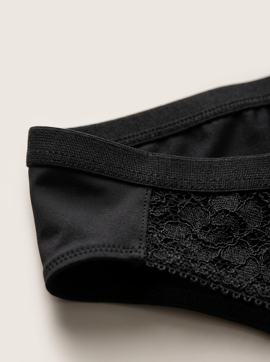 Black lace-trimmed bra on a beige background