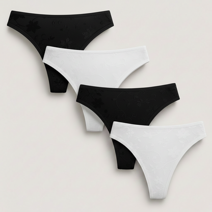 Four pairs of women's bikini-style underwear arranged diagonally on a light warm gray background. The set includes black, white, pink, and blue pieces, each with a subtle tonal floral vine pattern.